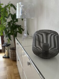 Moderne Dekoration mit schwarzem Kerzenhalter und transparenter Lampe auf weißem Sideboard in der Praxis Michael Backes in Ratingen.