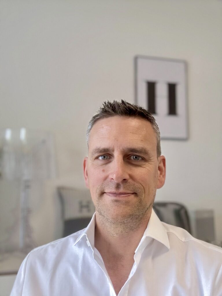 Mann im weißen Hemd in einer hellen Praxis für Psychotherapie und Business Coaching in Ratingen.
